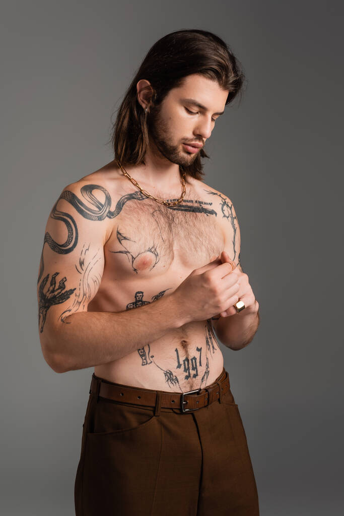 Shirtless and tattooed man standing isolated on grey  - Photo, image