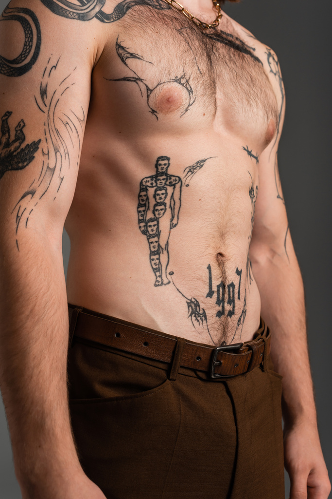 Rajattu näkymä tatuoitu ja paidaton mies eristetty harmaa  - Valokuva, kuva