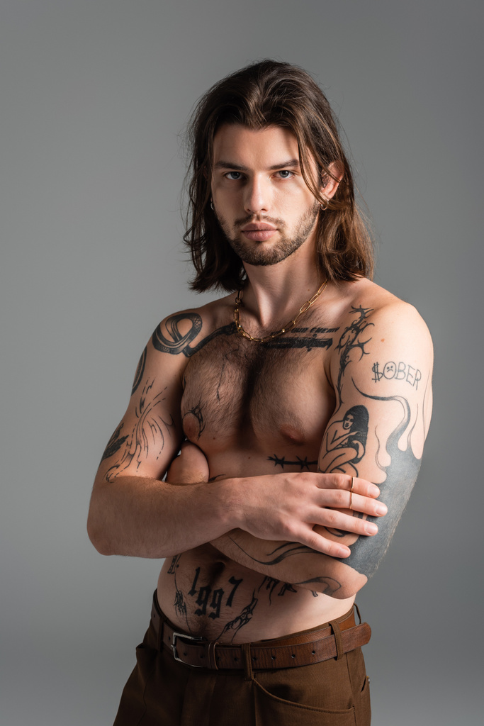 Muscular tattooed model posing while standing isolated on grey  - Foto, Imagem