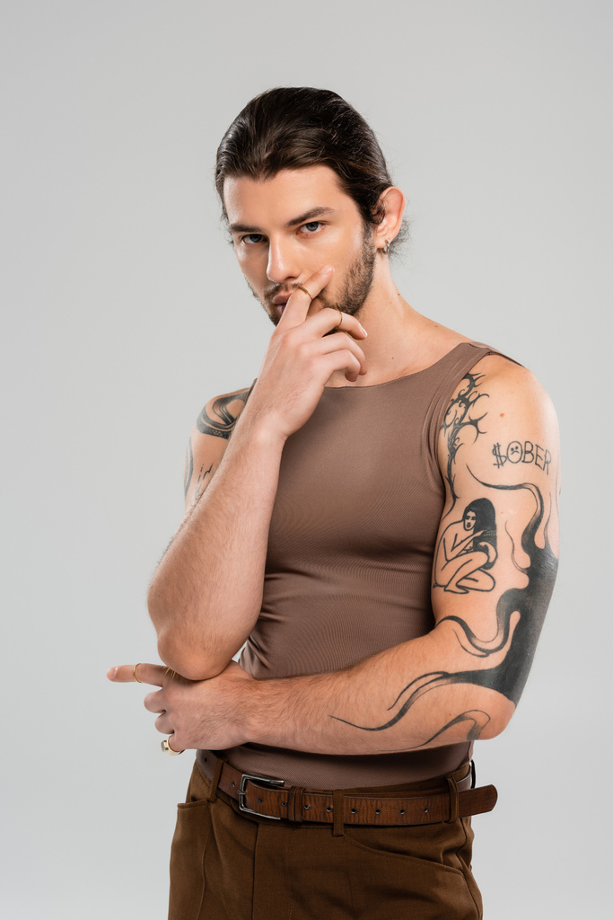 Young tattooed model in tank top posing isolated on grey  - Photo, image