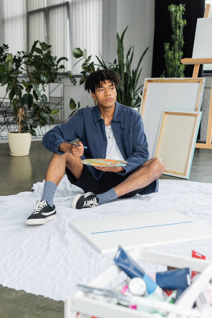 Artiste afro-américain tenant pinceau et palette en atelier  - Photo, image