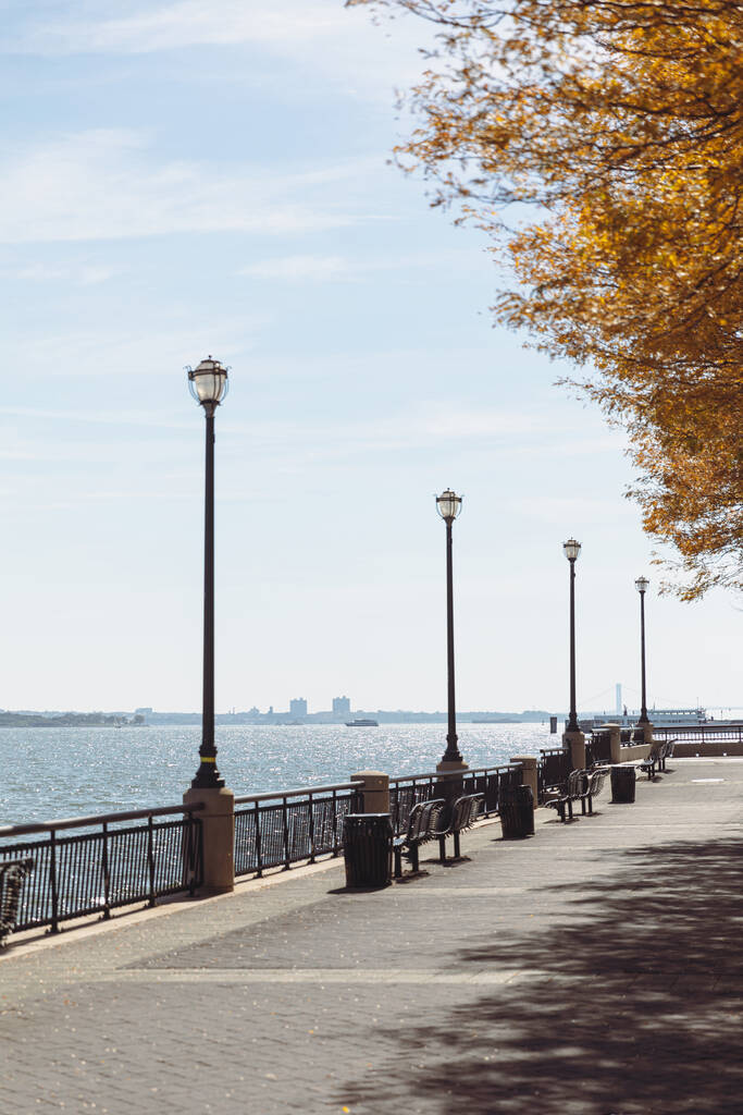набережная с фонарями и дорожкой возле речного залива в Нью-Йорке - Фото, изображение