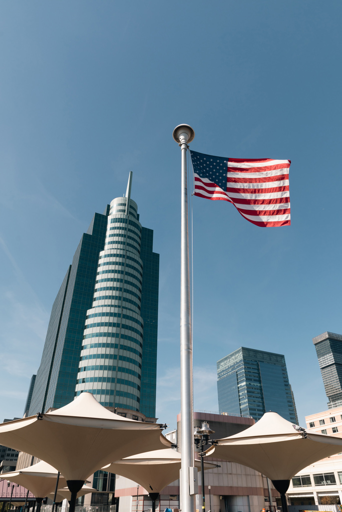 bandera de EE.UU. y sombrillas de sombra cerca de rascacielos en el distrito de Manhattan de la ciudad de Nueva York - Foto, imagen