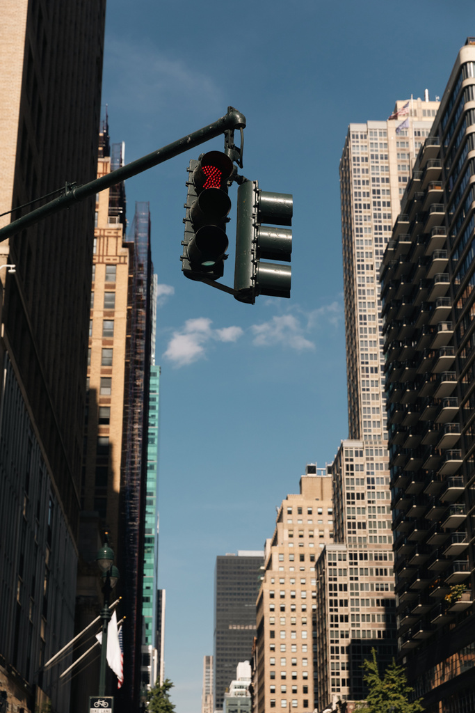 traffic light on city street near modern buildings in New York City against blue sky - Photo, image