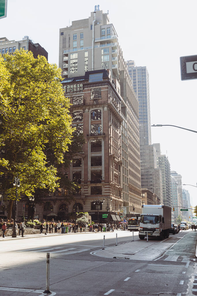 NEW YORK, USA - 13 OCTOBRE 2022 : arbre au feuillage automnal près des bâtiments et des piétons dans la rue de la ville - Photo, image