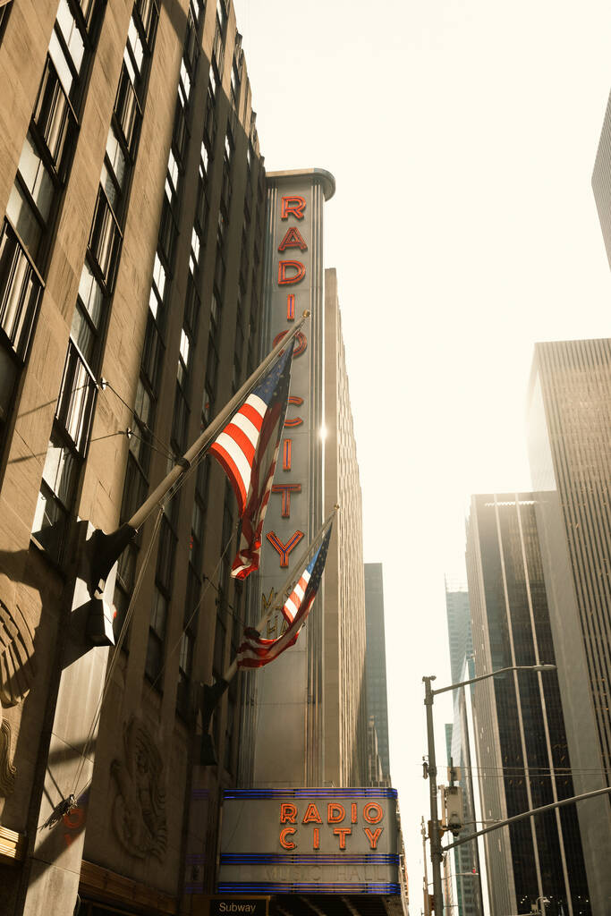ÚJ YORK, USA - Október 13, 2022: USA zászlók Radio City zeneterem épület Manhattan - Fotó, kép