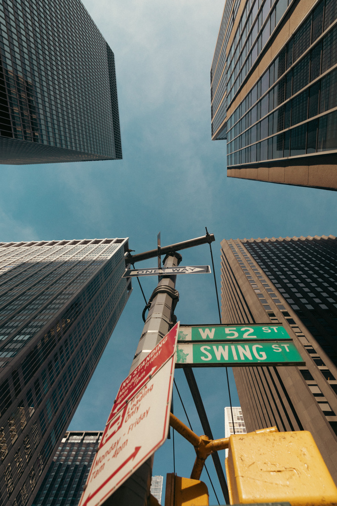 bottom view of road pole with pointers near skyscrapers in New York City - 写真・画像