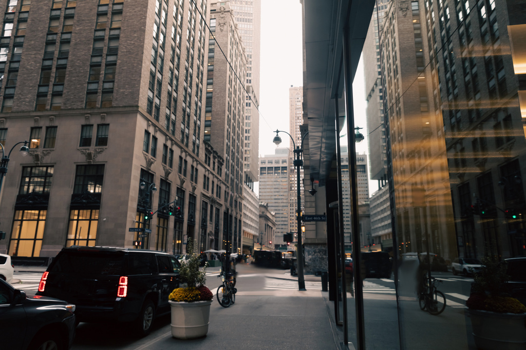 автомобильная дорога и тротуар между современными зданиями городской улицы в Нью-Йорке - Фото, изображение
