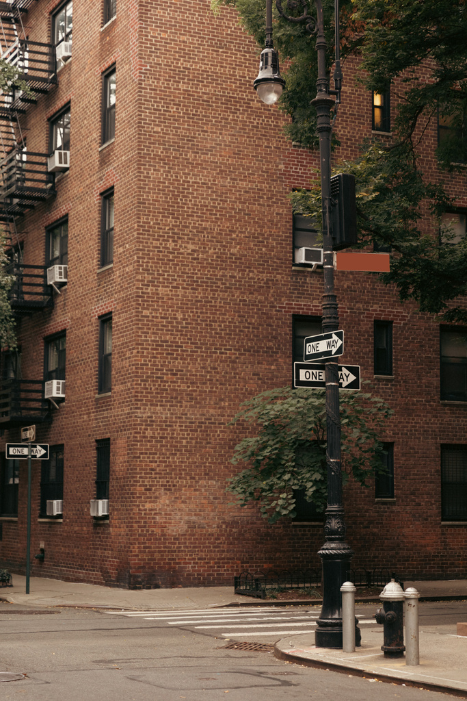 Punteros en la linterna cerca de la carretera y el edificio de ladrillo en la calle en la ciudad de Nueva York - Foto, Imagen