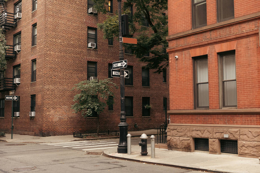 Wskaźniki między budynkami murowanymi na ulicy w Nowym Jorku - Zdjęcie, obraz
