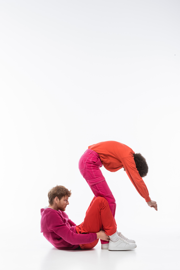side view of interracial couple in magenta color clothes showing s letter on white background  - Φωτογραφία, εικόνα