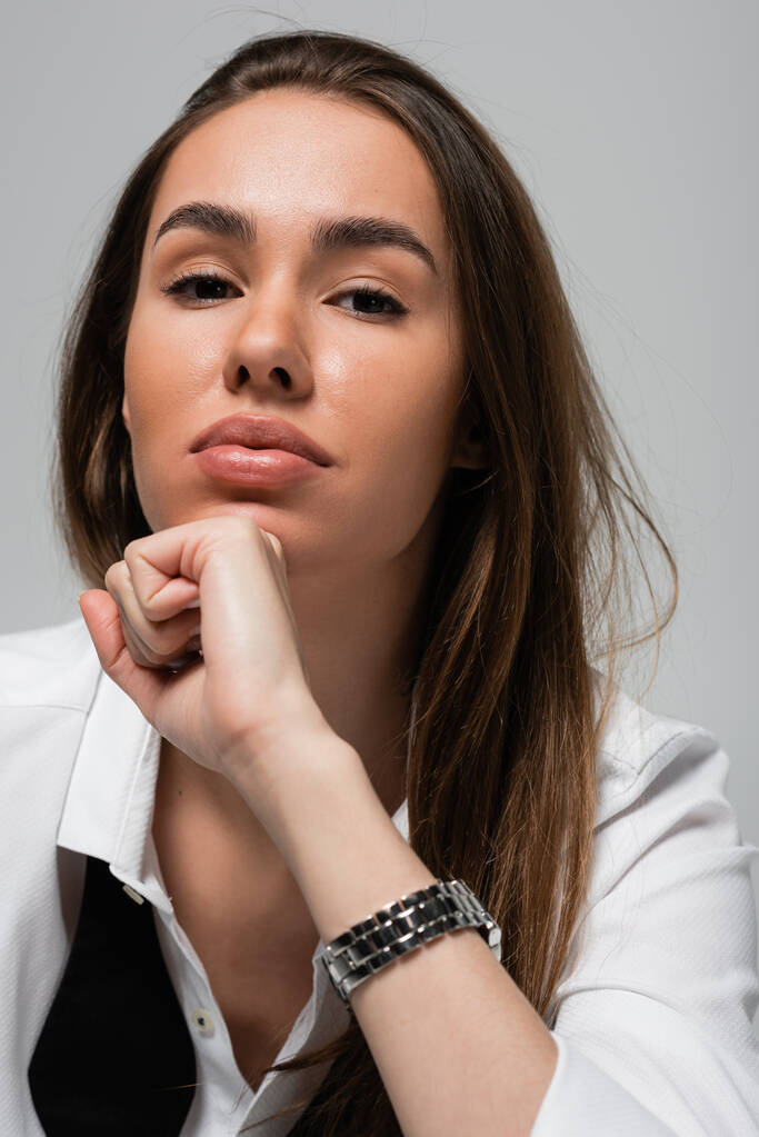 portrait of brunette woman in white shirt looking at camera isolated on grey  - Photo, Image
