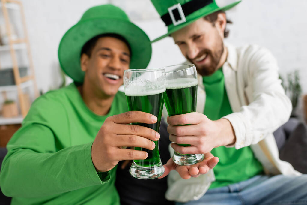 Blurred multiethnic friends clinking green beer during saint patrick day - Fotografie, Obrázek