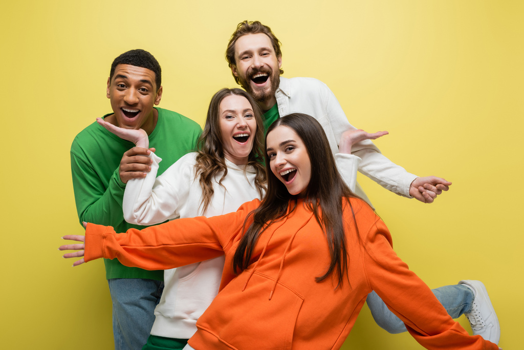 Opgewonden interraciale vrienden hebben plezier op gele achtergrond  - Foto, afbeelding