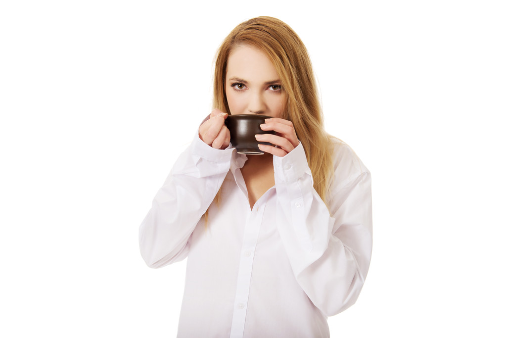 Жінка в сорочці з довгим рукавом п'є каву
. - Фото, зображення