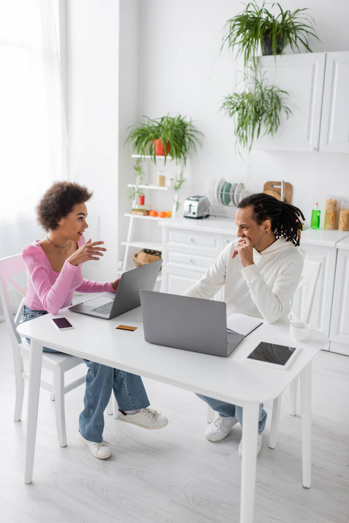 African american freelancers talking near devices in kitchen  - Photo, image