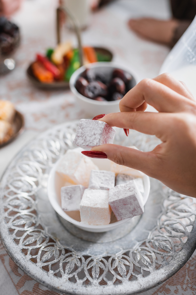 Cropped view of muslim woman holding turkish delight during ramadan morning  - Photo, Image