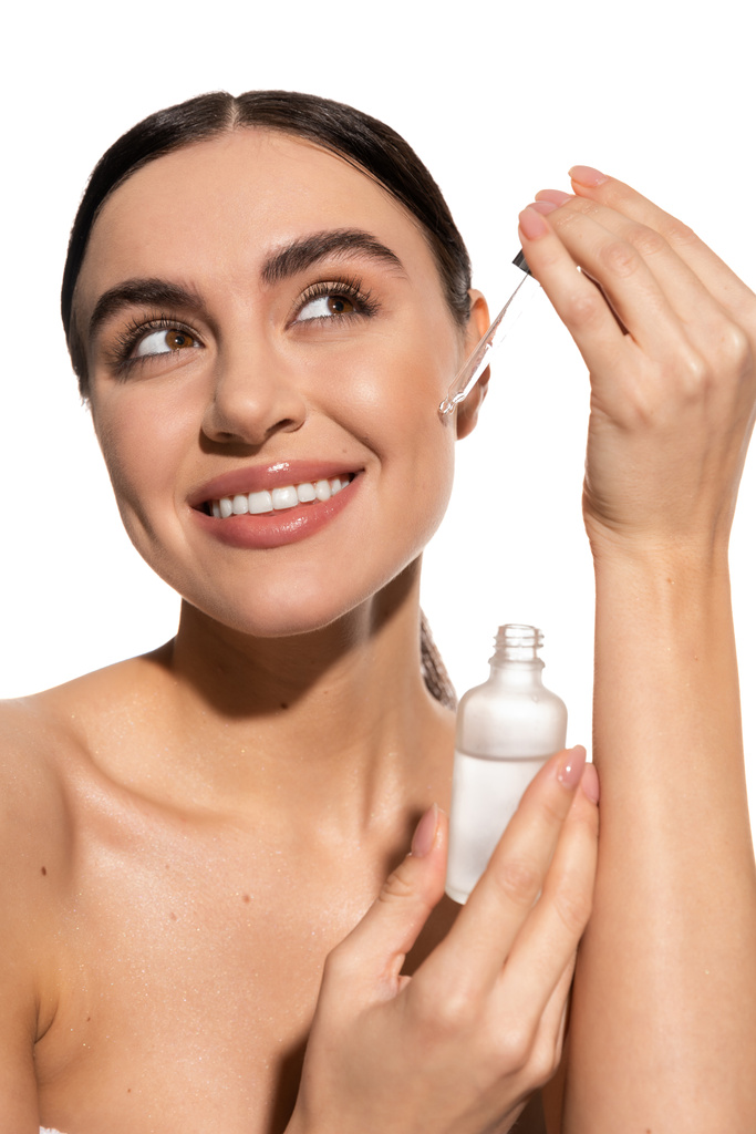 smiling woman holding dropper with vitamin c serum isolated on white  - Fotó, kép
