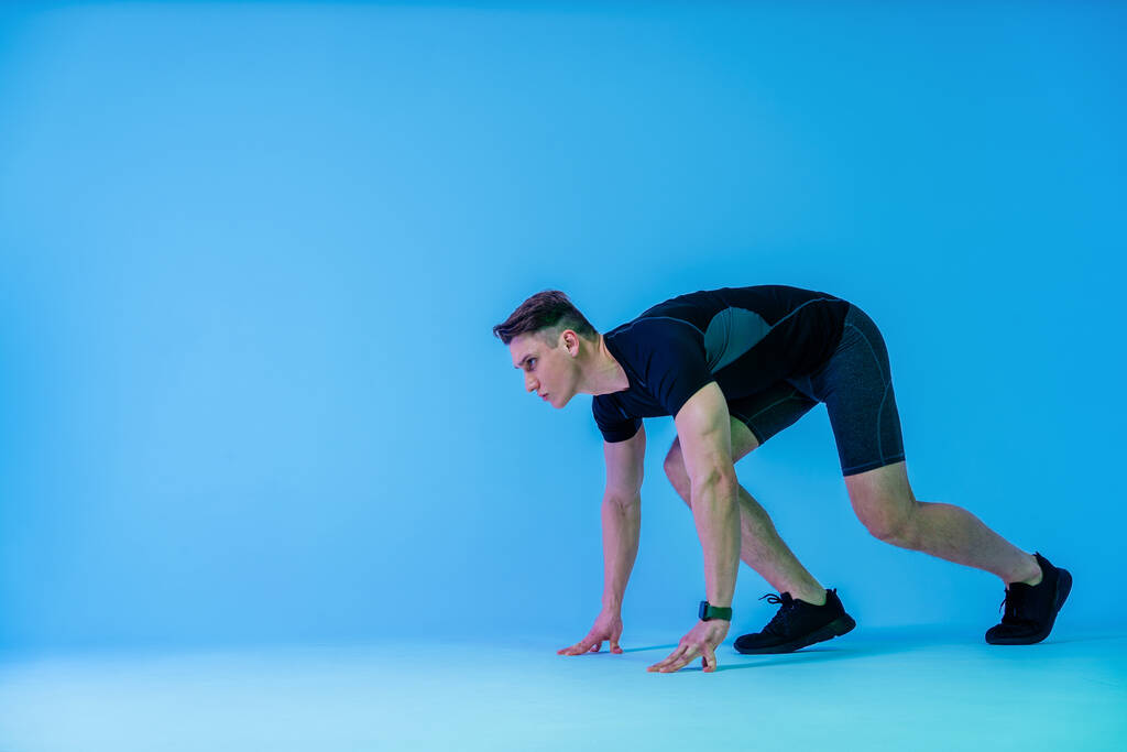 Athletischer Mann mit fittem muskulösem Körpertraining im Studio - Aktiver Mann beim Workout, bunte Beleuchtung und Hintergrund, Konzepte zu Fitness, Sport und Gesundheitsstil - Foto, Bild