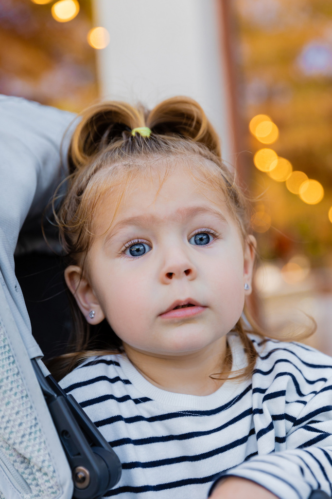 portré kisgyerek csíkos hosszú ujjú ing ül a baba babakocsi  - Fotó, kép