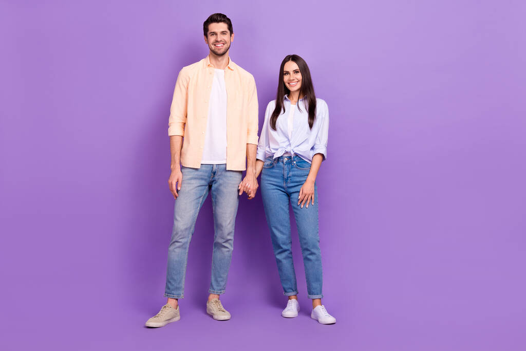 Full size photo of two positive people hold hands toothy smile good mood isolated on violet color background. - Fotoğraf, Görsel