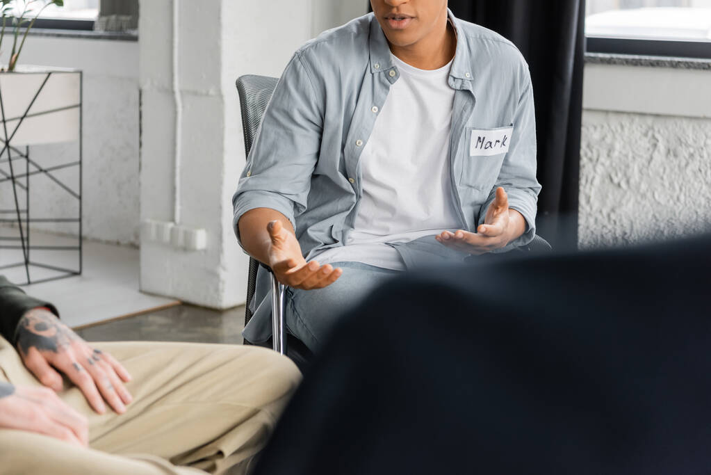 Gewassen beeld van de Afrikaanse Amerikaanse man met alcoholverslaving praten tijdens therapie in afkickkliniek  - Foto, afbeelding