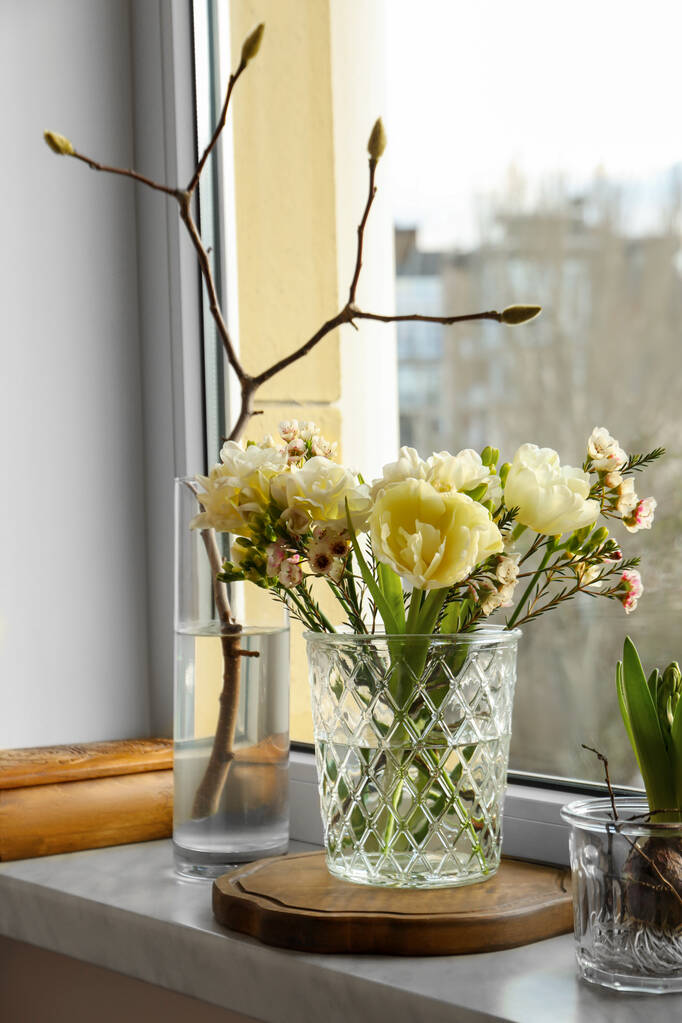 Hermosas flores de primavera en jarrón en el alféizar de la ventana en interiores - Foto, Imagen
