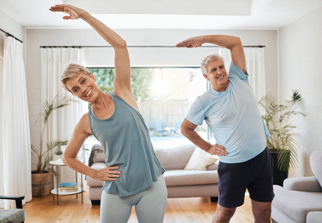Stretching, yoga and fitness with a middle aged couple doing an exercise, workout or training at home. Health and wellness, lifestyle and active with a fit elderly man and woman exercising in a house. - Photo, Image