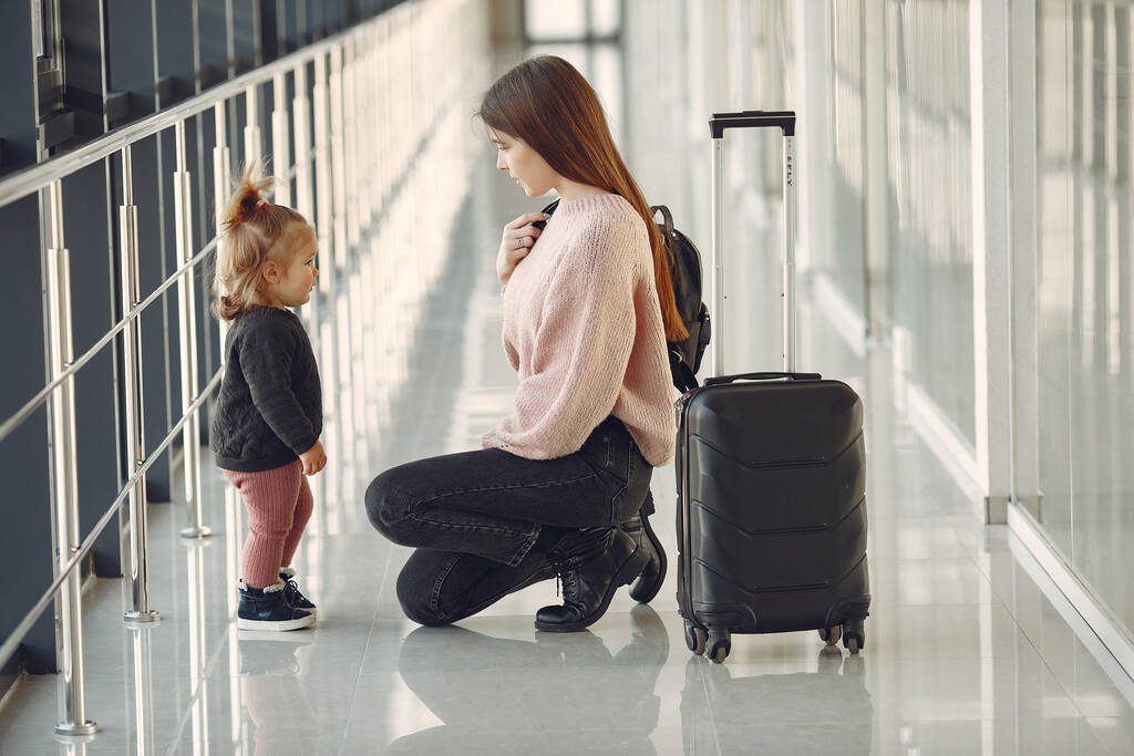 Family at the airport. Mother with daughter. Woman with suitcase. - Photo, Image