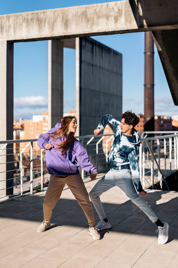 Στοκ φωτογραφία του ευτυχισμένου κοριτσιού και ο φίλος της εξάσκηση κινήσεις χορού τους και τη διασκέδαση. - Φωτογραφία, εικόνα