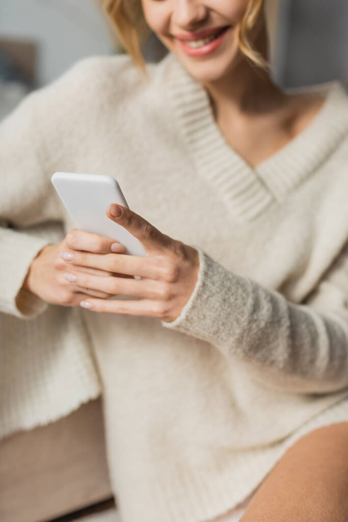 kivágott kilátás boldog nő kötött pulóver csevegés okostelefon otthon - Fotó, kép