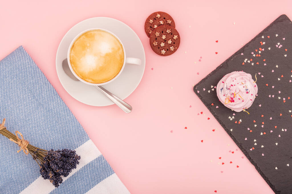 Cup of coffee with a cupcake and cookies on a pink background, top view. Confectionery, patisserie - sweet food - Photo, Image