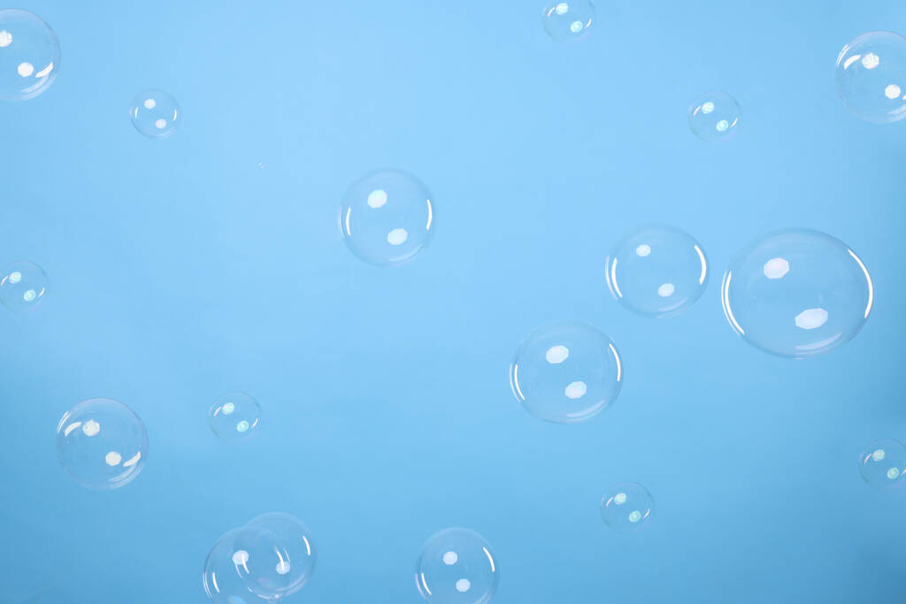 Many beautiful soap bubbles on light blue background - Fotoğraf, Görsel