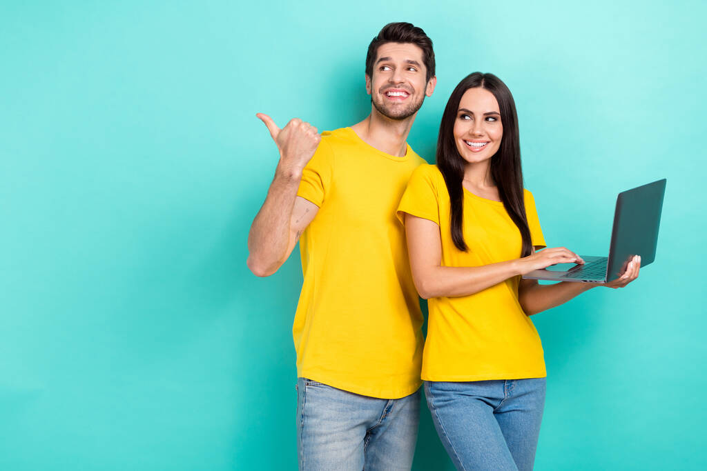 夢のような甘い結婚したカップルの写真は、黄色のTシャツタイプデバイス親指空のスペース孤立ターコイズ色の背景を身に着けています. - 写真・画像
