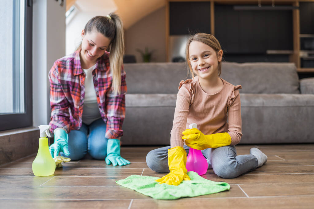 Boldog lány és anya takarítás ház együtt. - Fotó, kép