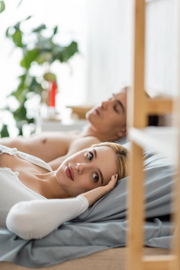 verwarde blonde vrouw wakker met vreemdeling man in haar bed na een nacht stand  - Foto, afbeelding