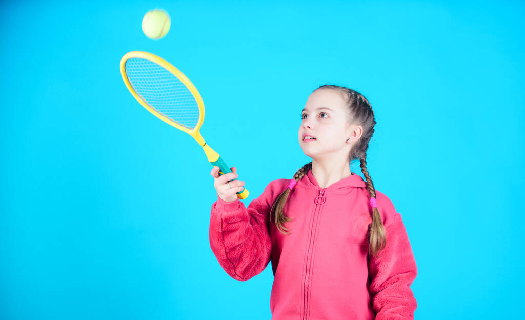 Tennispelaaja mailalla ja pallolla. Lapsuuden harrastus. Onnellinen lapsi pelaa tennistä. Teinitytön jumppamaikka. Pikkutyttö. Fitness ruokavalio tuo terveyttä ja energiaa. Urheilupelitoimintaa. onnellinen lapsuus
. - Valokuva, kuva