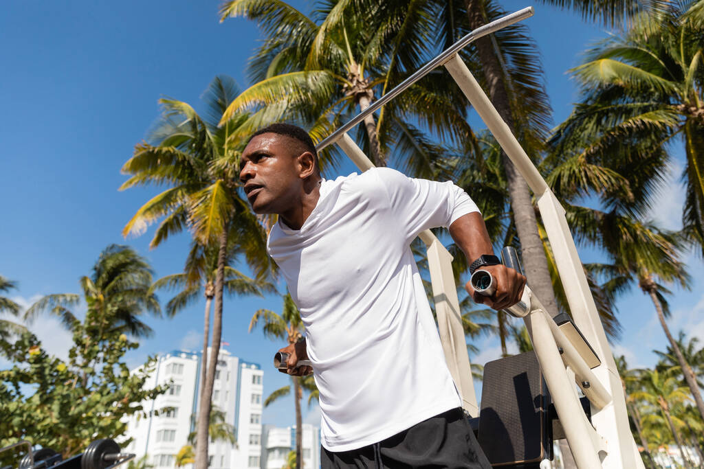 vista a basso angolo dello sportivo afro-americano che lavora sulla spiaggia di Miami  - Foto, immagini