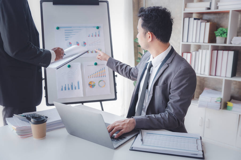 Finance and investment concept, Businessman present business finance investment plan with his partner, Investor colleagues discussing new investment plan by financial graph data on office table - Foto, Imagen