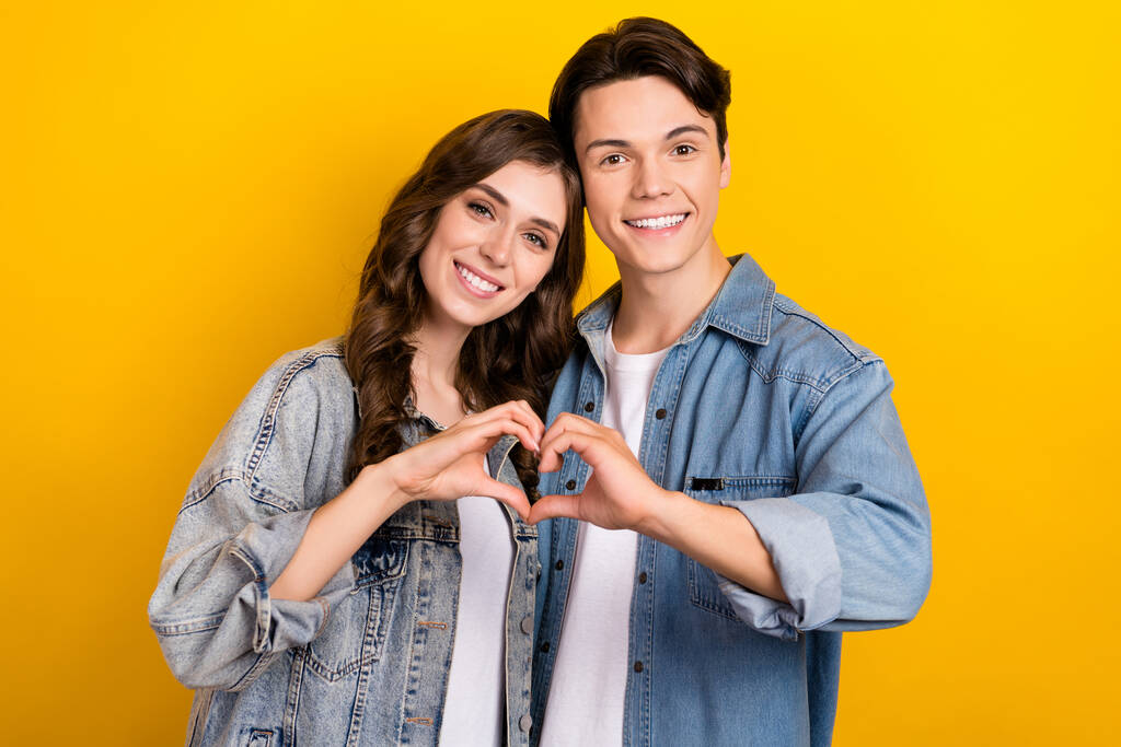 Porträt zweier friedlicher idyllischer Partner Arme Finger zeigen Herzsymbol isoliert auf gelbem Hintergrund. - Foto, Bild