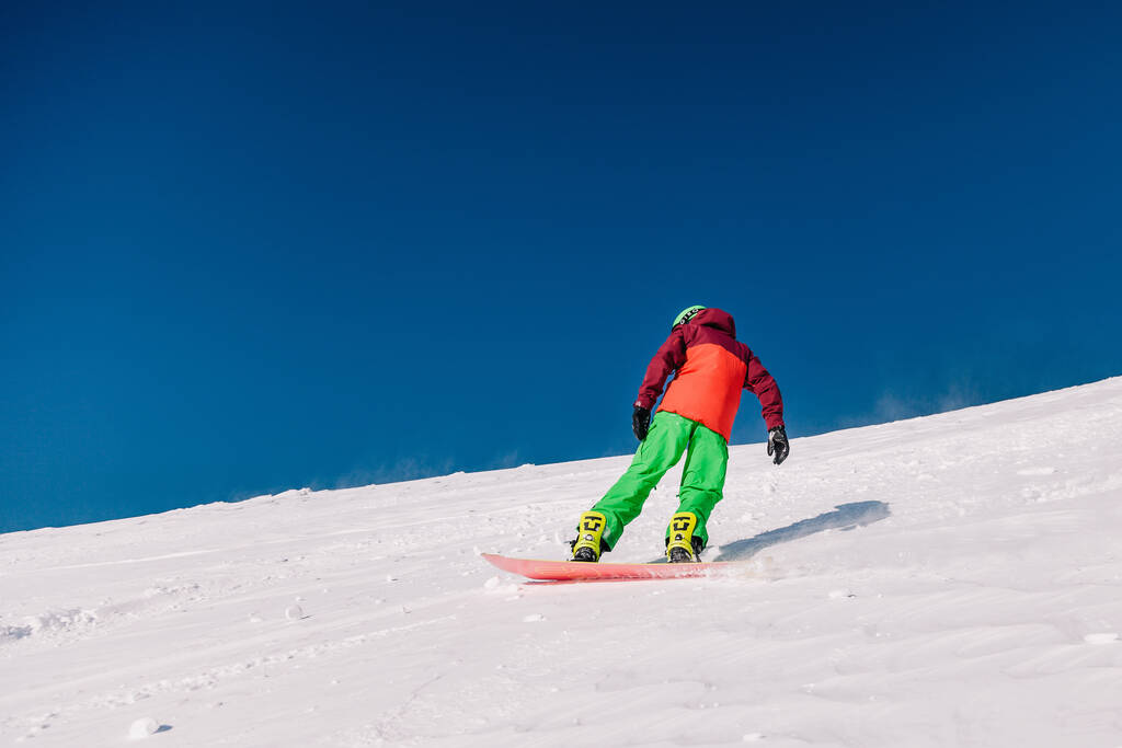 Karpaty, Ukraine, February 8, 2023. Skiers and snowboarders freeride in clear sunny weather on the slopes of the mountains near the resort of Dragobrat. High quality photo - Foto, Imagen