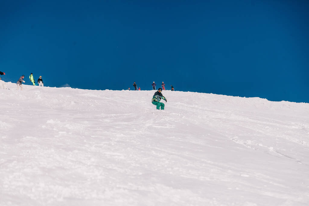 Καρπάτι, Ουκρανία, 8 Φεβρουαρίου 2023. σκιέρ και snowboarders freeride σε σαφή ηλιόλουστο καιρό στις πλαγιές των βουνών κοντά στο θέρετρο του Dragobrat. Υψηλής ποιότητας φωτογραφία - Φωτογραφία, εικόνα