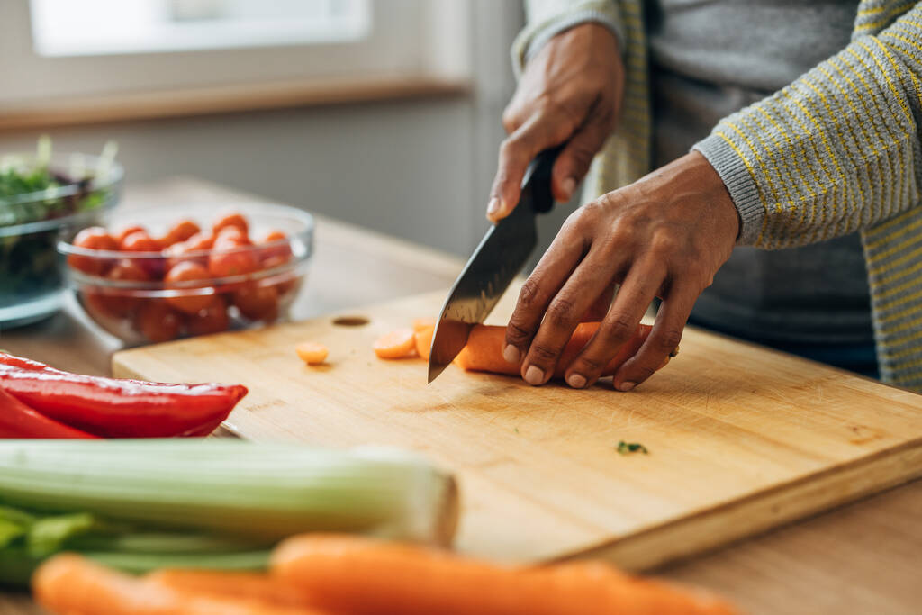 Widok z bliska warzywa na stole, krojenie marchwi na desce do krojenia - Zdjęcie, obraz