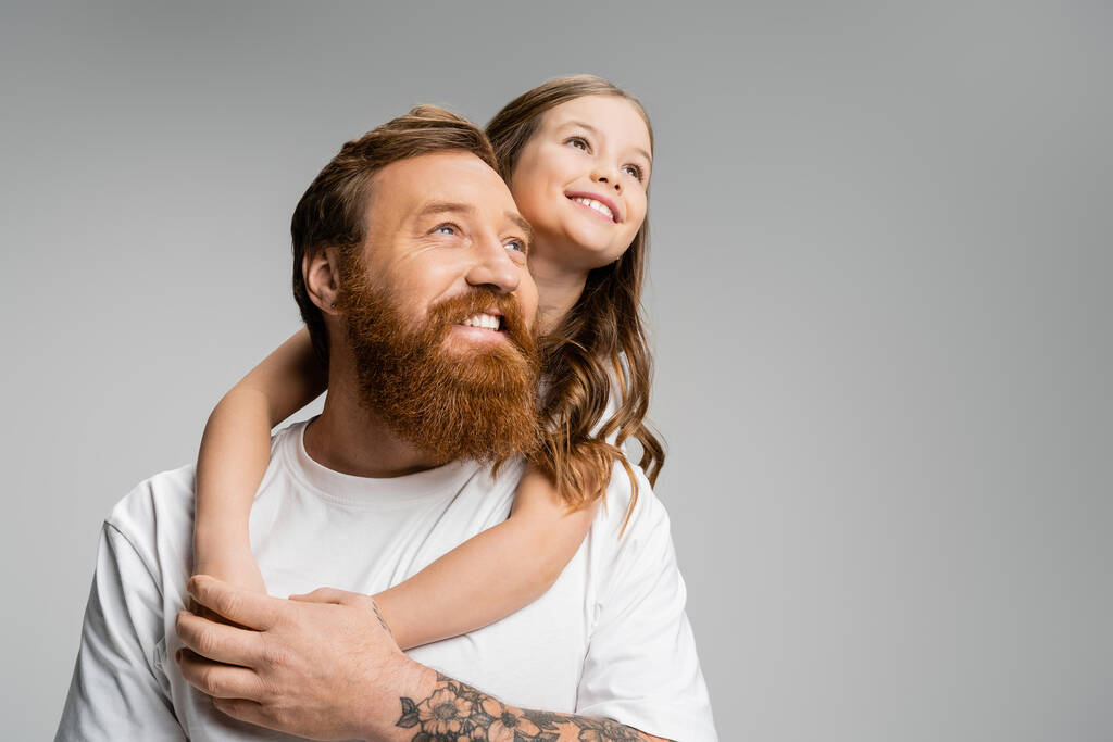 Positive girl hugging father and looking away isolated on grey  - Photo, Image