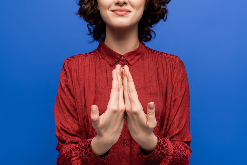 μερική άποψη της ευτυχούς γυναίκας που μιλάει στη νοηματική γλώσσα απομονωμένη στο μπλε - Φωτογραφία, εικόνα
