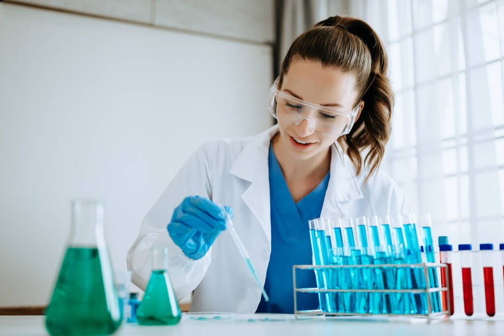Vrouwelijke biotechnoloog test nieuwe chemische stoffen in een laboratorium. - Foto, afbeelding