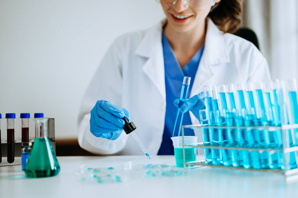 女性科学者研究者が化学実験室で実験を行う - 写真・画像