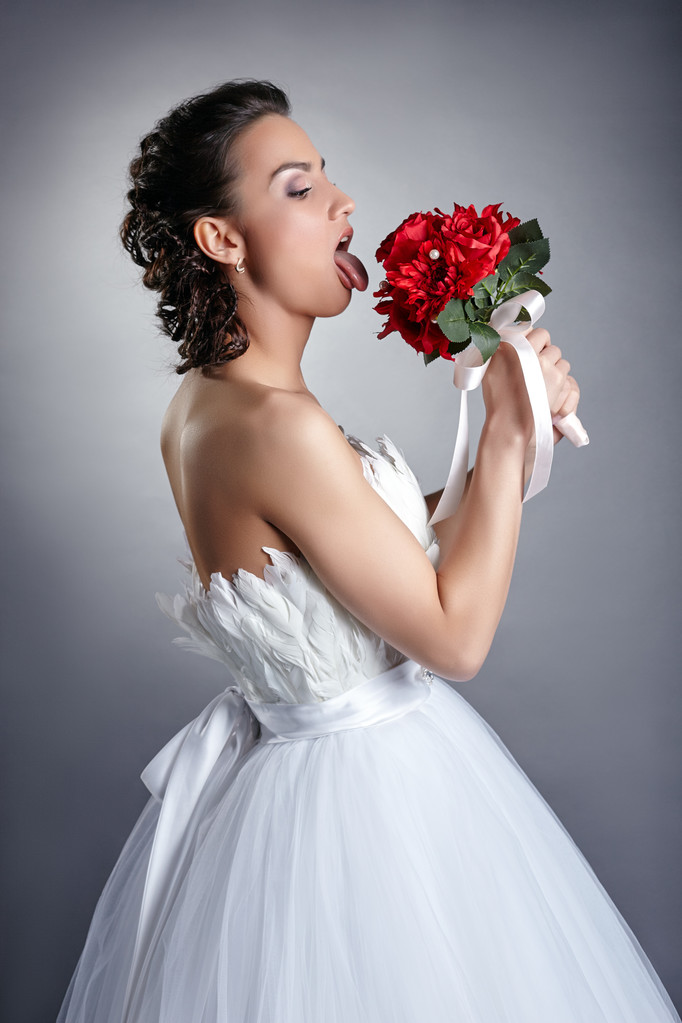 Pretty bride fooling around with bouquet - Photo, Image