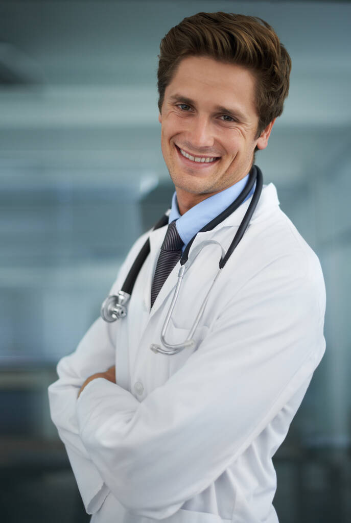Il a confiance en vous. Portrait d'un beau jeune médecin avec un stéthoscope autour du cou souriant à la caméra - Photo, image