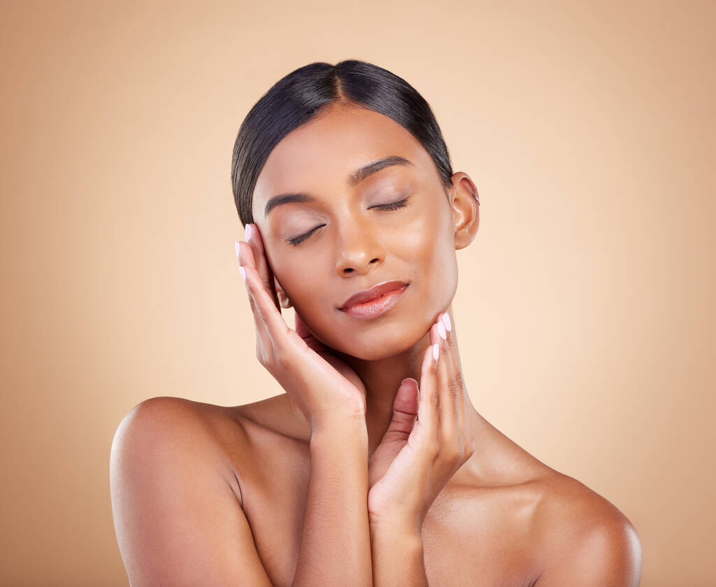 Skincare, self love and hands on face of woman in studio for beauty, wellness and relax on brown background. Skin, satisfaction and girl model enjoy body care, cosmetics and treatment while isolated. - Photo, Image